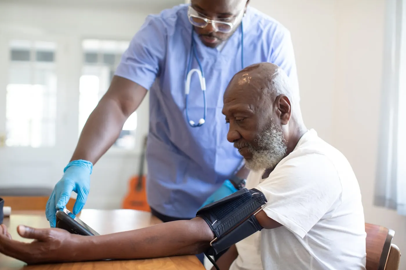 A health worker checking a patient's blood pressure